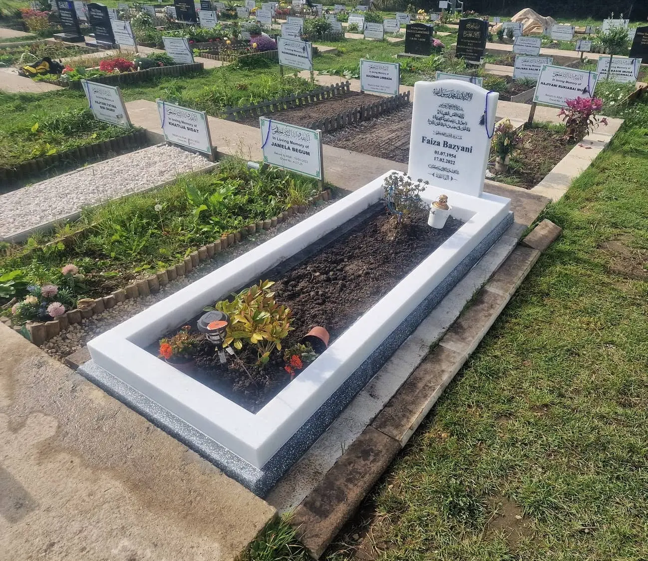 White headstone and matching kerb surround in a cemetery